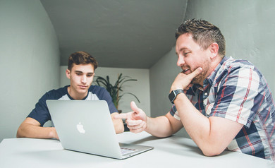 Deux hommes travaillent ensemble sur un ordinateur portable