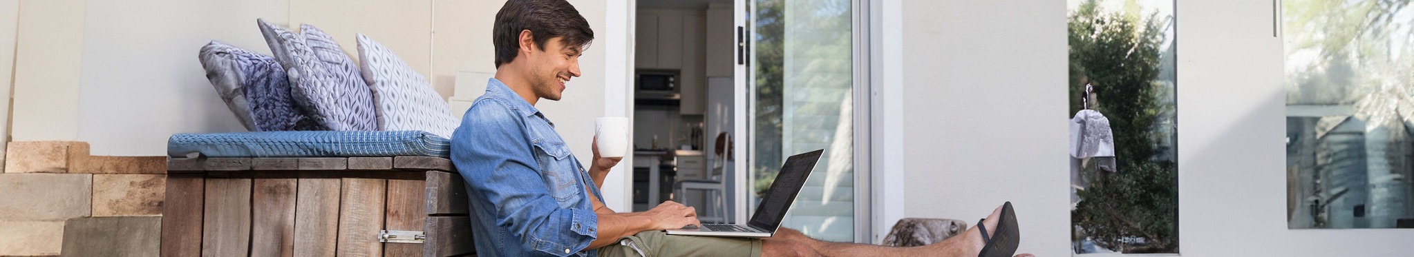 Mann sitzt auf Terrasse und freut sich über seine digitale Zeiterfassung.